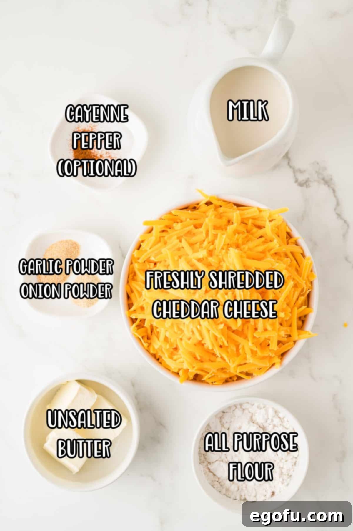 A vibrant flat lay of all the essential ingredients for homemade Nacho Cheese Sauce: whole milk, a block of cheddar cheese, unsalted butter, all-purpose flour, garlic powder, onion powder, and a dash of cayenne pepper.