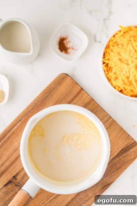Milk being whisked into the butter and flour roux.