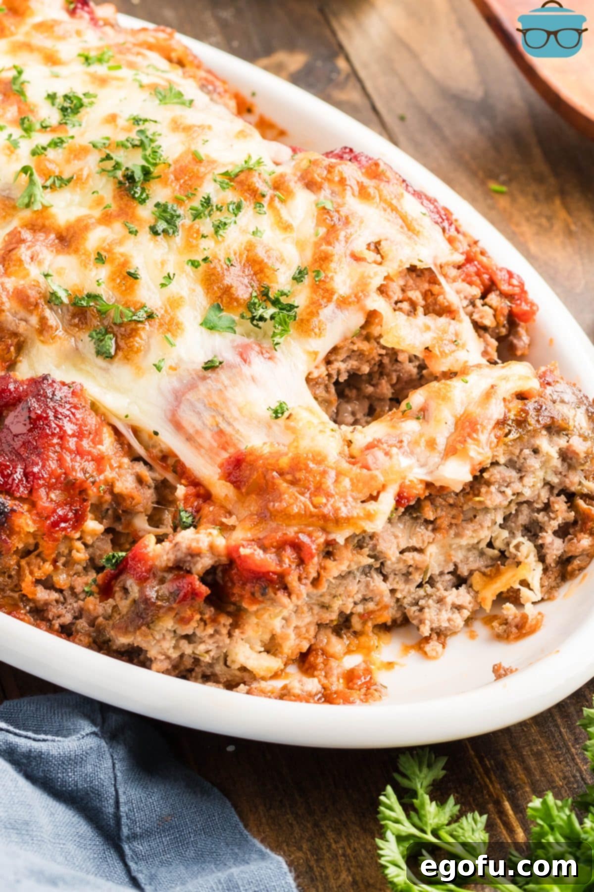 Grandma's Secret Italian Meatloaf 2 A perfectly cooked Italian Meatloaf, sliced and garnished with fresh parsley, ready to be served.