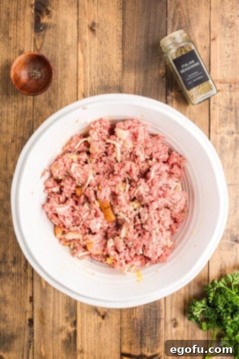 Grandma's Secret Italian Meatloaf 12 A bowl with beef, bread, milk, eggs, minced garlic, Italian seasoning, garlic powder, onion powder and 1 cup shredded mozzarella cheese.