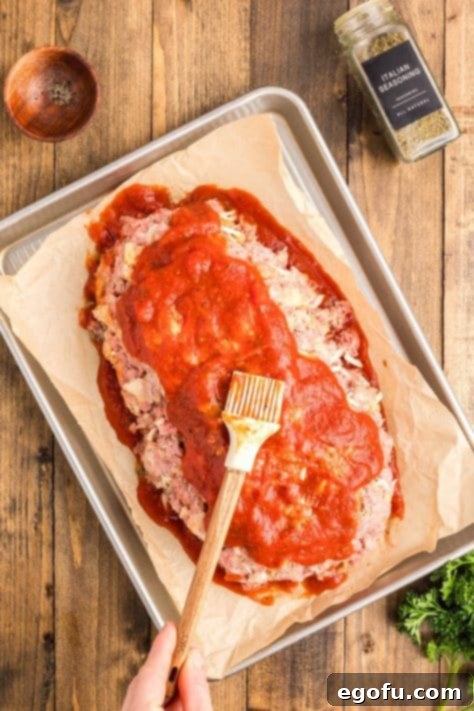 Grandma's Secret Italian Meatloaf 14 Sauce spread over unbaked meatloaf.