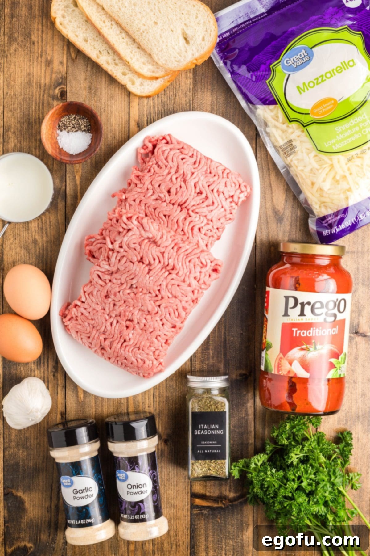 Grandma's Secret Italian Meatloaf 4 An array of fresh ingredients for Italian Meatloaf including ground beef, mozzarella, eggs, marinara, Italian bread, milk, garlic, and seasonings.