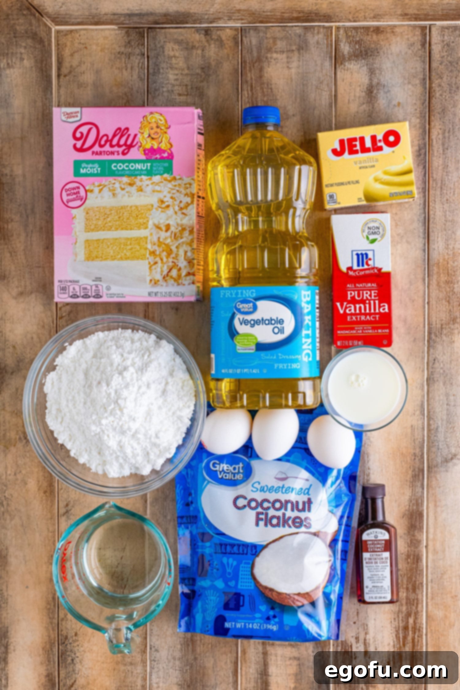 Tropical Coconut Bake 4 Coconut cake mix, instant vanilla pudding mix, water, sweetened coconut flakes, vegetable oil, eggs, powdered sugar, milk, coconut extract, and vanilla extract.