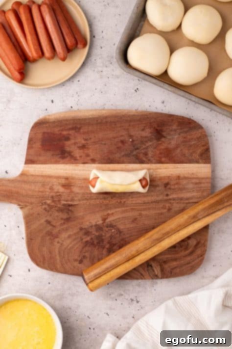 Hearty Texas Sausage Kolaches 13 A sausage wrapped up in a flattened dinner roll.