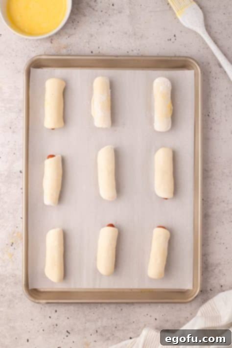 Hearty Texas Sausage Kolaches 14 Unbaked Kolaches on a lined baking sheet.