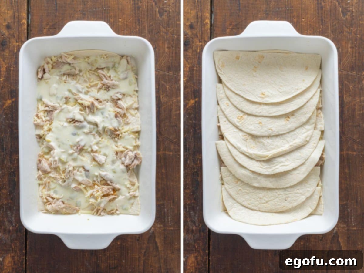 A layer of chicken, sauce, and tortillas in a baking dish, illustrating the progression of the casserole layers.