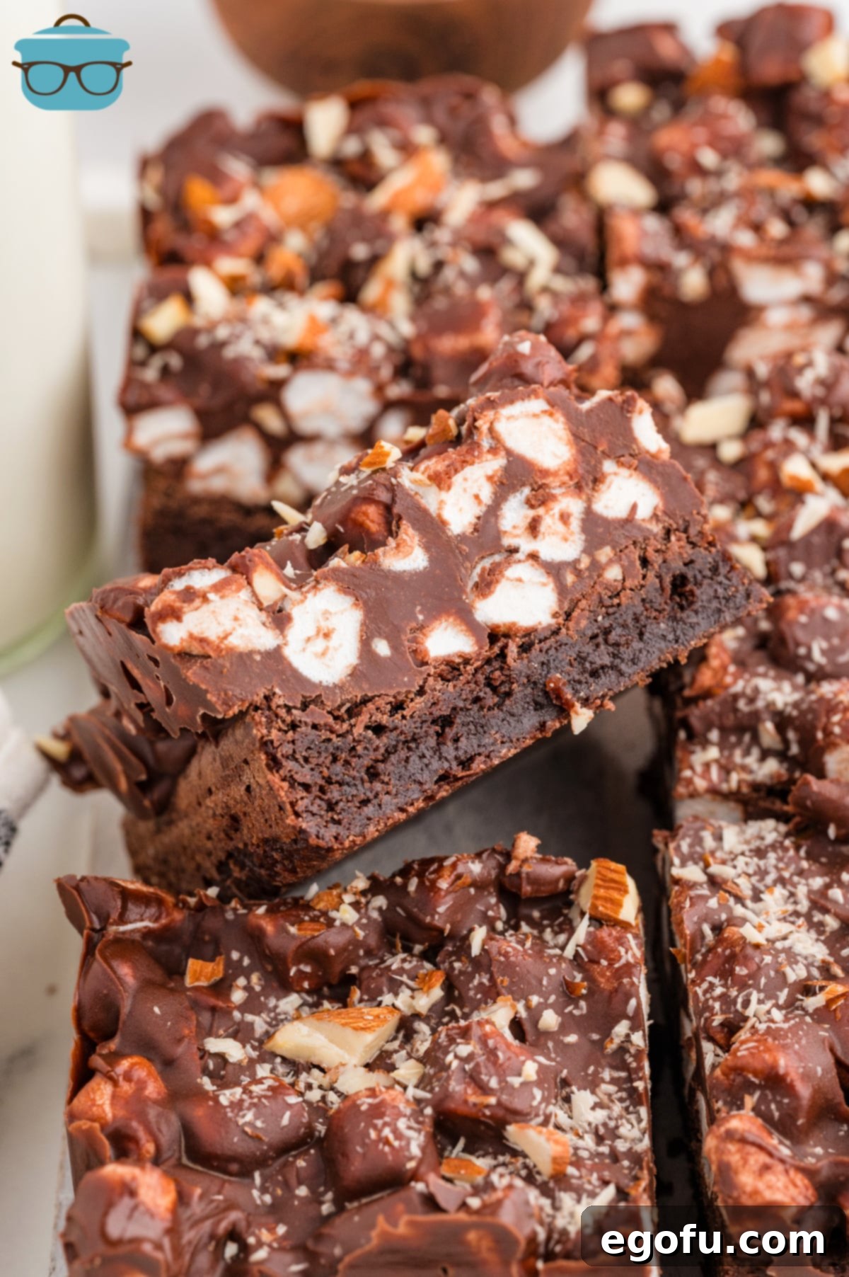 Rocky Road Bliss Bars 2 A bunch of Rocky Road Brownies, one missing a bite, showing the rich chocolate, marshmallows, and almonds.