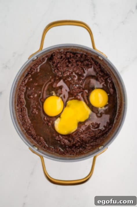 Rocky Road Bliss Bars 14 Eggs and vanilla being added to a batter.