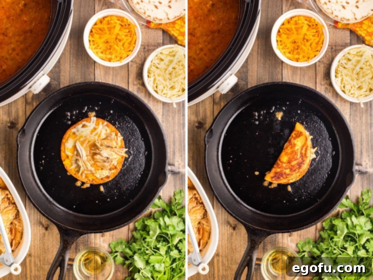 A Buffalo Chicken Taco in the process of being folded in a skillet, showing crispy edges and melted cheese.