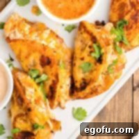 Looking down on a few Buffalo Chicken Tacos with a small cup of dipping sauce.