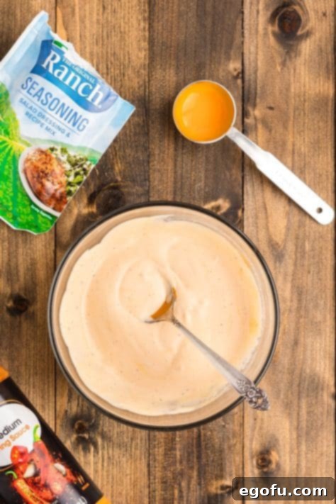 Buffalo sauce mixture being mixed together in a bowl.