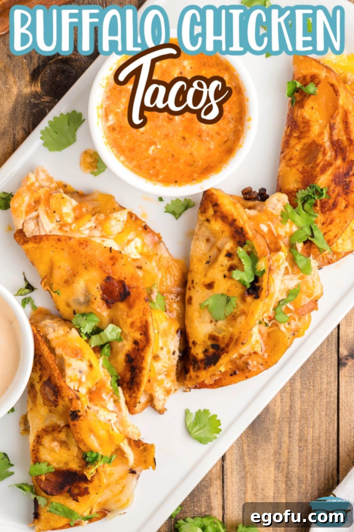 A serving platter beautifully arranged with several homemade buffalo chicken tacos, garnished with fresh cilantro and a side of dipping sauce.