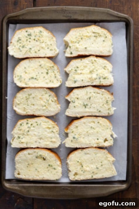 Bread slices with butter on them on a baking sheet.