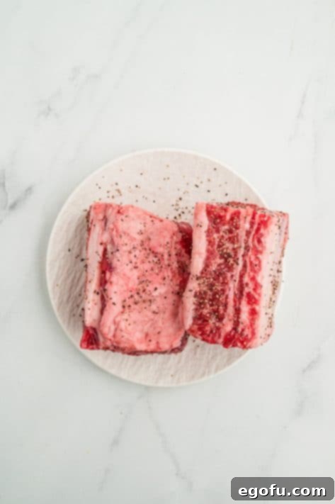 Short ribs with salt and pepper on a plate.