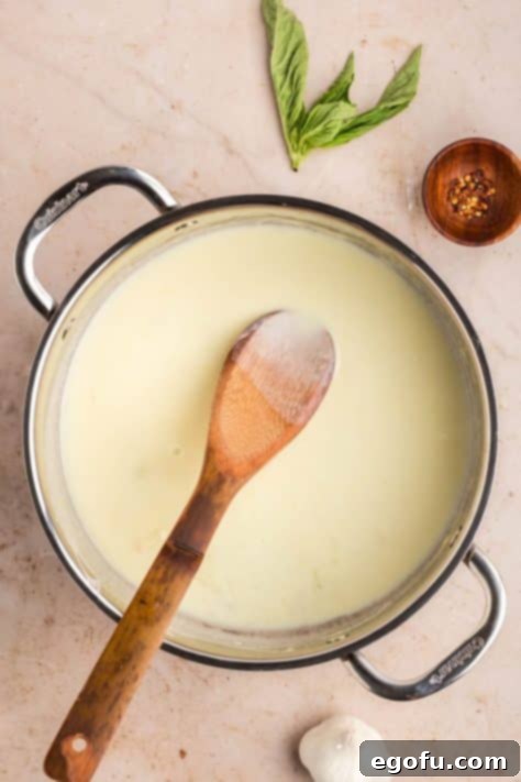 Heavy cream added to sauce ina pan.