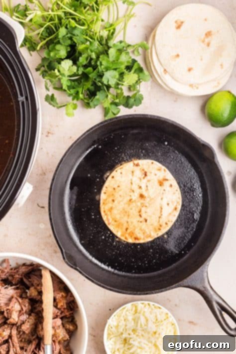 A taco shell cooking in oil in a skillet.