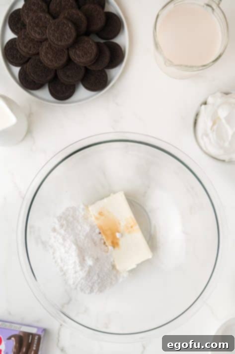 A bowl with cream cheese, sugar, and vanilla extract to be mixed.