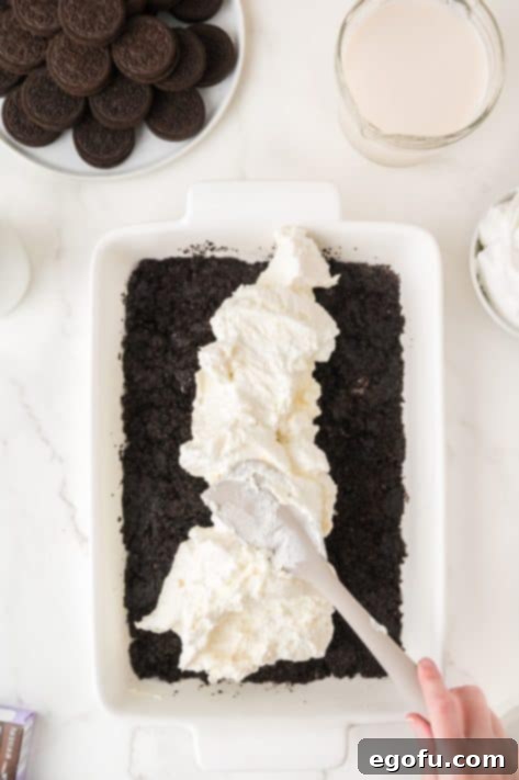 Cream cheese layer being spread over the Oreo layer.