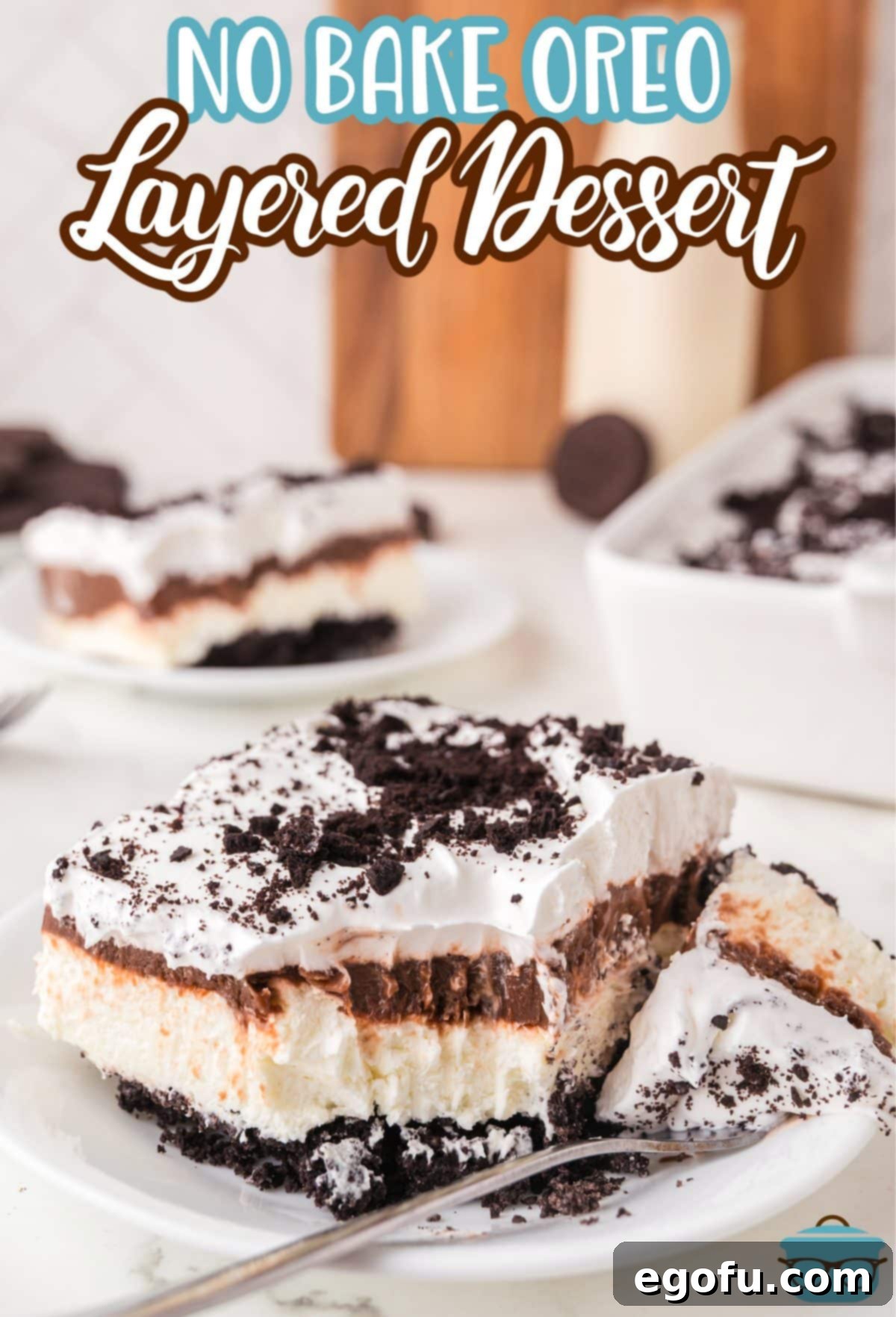 A fork holding a bite of the slice of Oreo No Bake Layered Dessert.