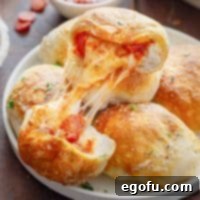 Close up looking at a broken open Air Fryer Pizza Bomb, revealing melted cheese and pepperoni.