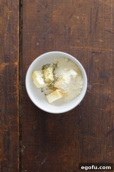 A small bowl with butter, garlic powder and Italian seasoning.