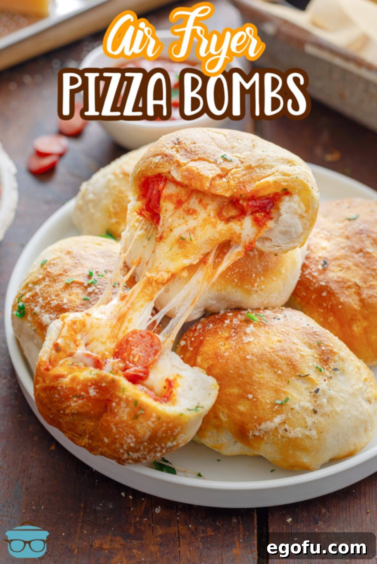 A serving plate with a pile of golden, cheesy Air Fryer Pizza Bombs.