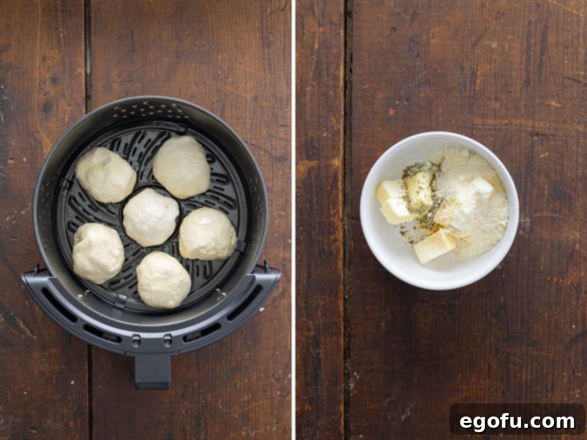 Uncooked pizza bombs arranged neatly in an Air Fryer basket alongside a small bowl of butter and seasonings.