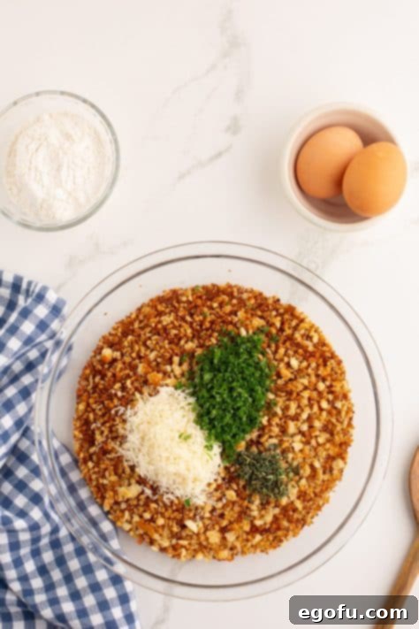 breadcrumbs, parmesan cheese and herbs added to a large plate.