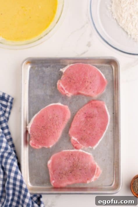 Seasoned pork chops on a sheet pan.