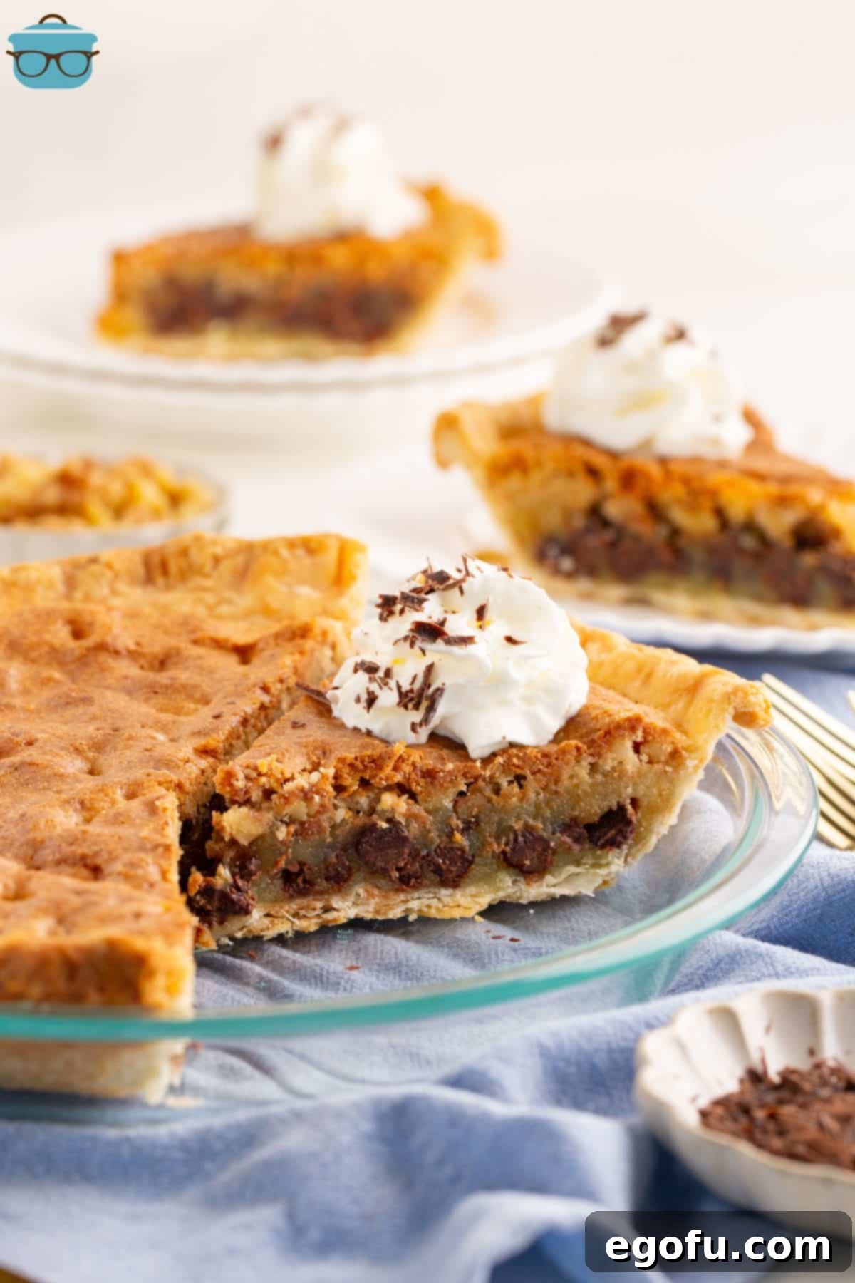 A golden-brown Kentucky Derby Pie, freshly baked and missing one perfect slice, showcasing its rich chocolate and walnut filling.