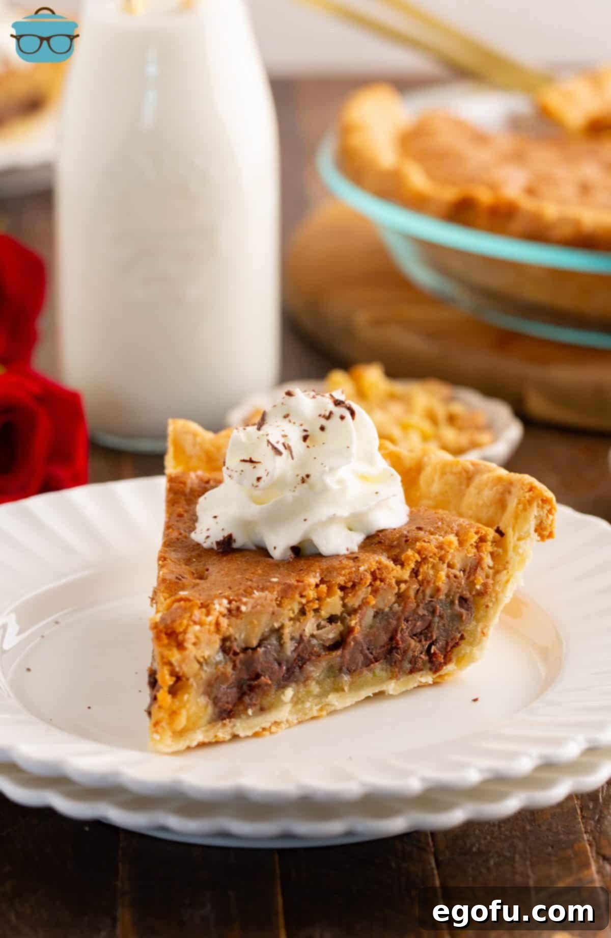 A delectable slice of Kentucky Derby Pie, topped with a swirl of fresh whipped cream and ready to be enjoyed.