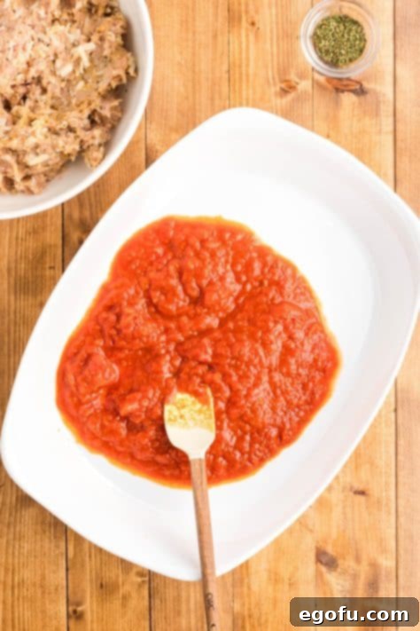 Chicken Parm Meatball Bake 13 Marinara sauce in a baking dish, providing a rich base for the meatballs.