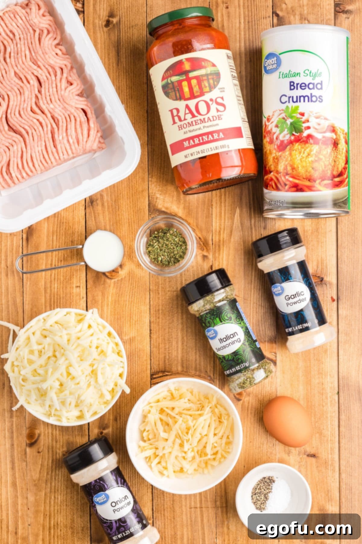 Chicken Parm Meatball Bake 5 A vibrant flat lay image showcasing all the ingredients: ground chicken, shredded mozzarella, shredded Parmesan, Italian bread crumbs, egg, milk, Italian seasoning, garlic powder, onion powder, salt, pepper, marinara sauce, and fresh parsley.