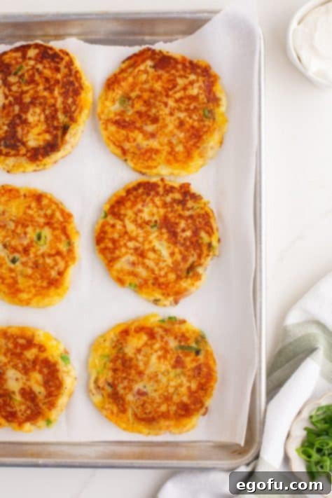 Crispy Potato Fritters 12 A few Potato Cakes on a lined baking sheet.