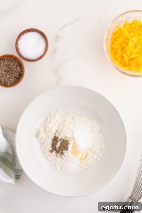 Crispy Potato Fritters 9 A bowl with flour, baking powder, garlic powder, salt, and pepper.