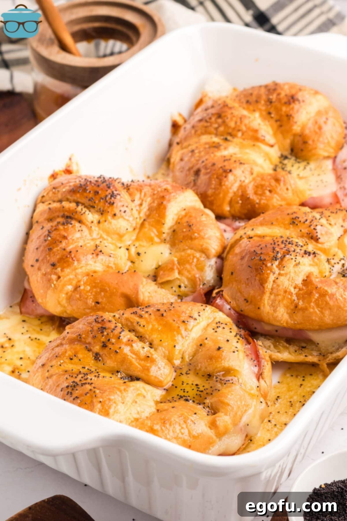A baking dish with a few Baked Ham and Cheese Croissants.
