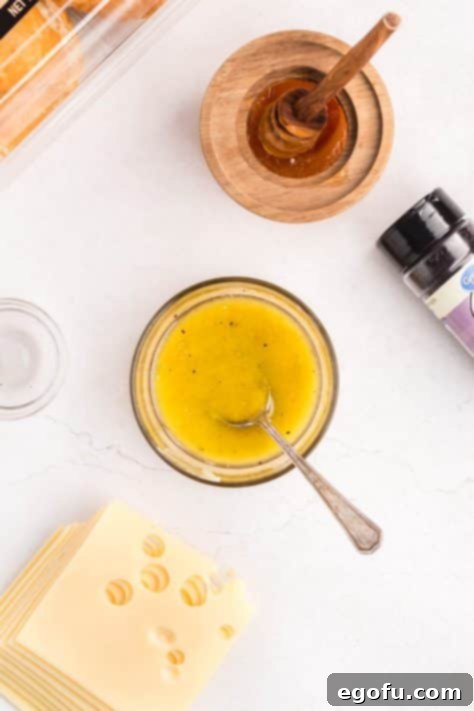 A bowl with butter, honey, brown sugar, Dijon mustard, salt, and pepper.