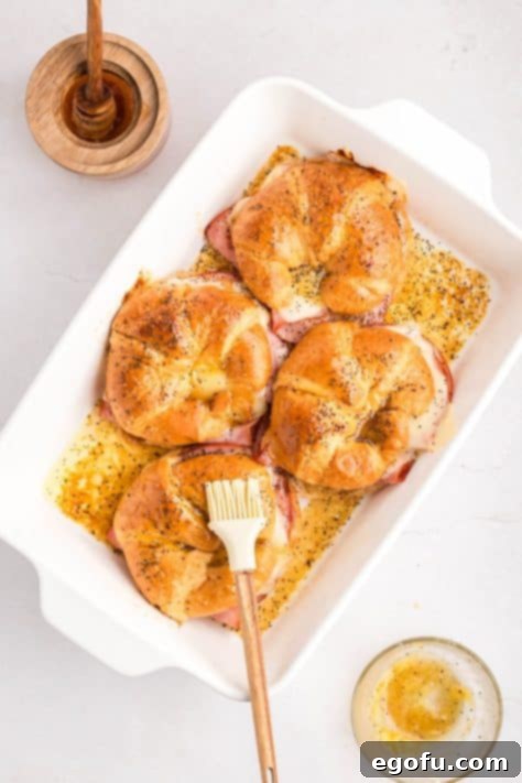 Pastry brush brushing butter mixture on the croissants.