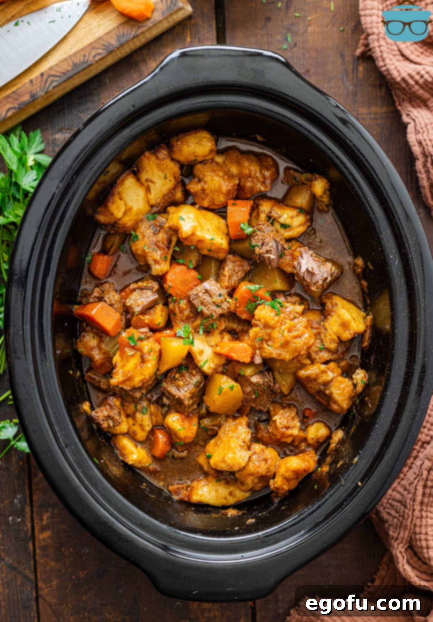 Looking down on a Slow Cooker full of Beef and Dumplings, steaming and ready to serve.