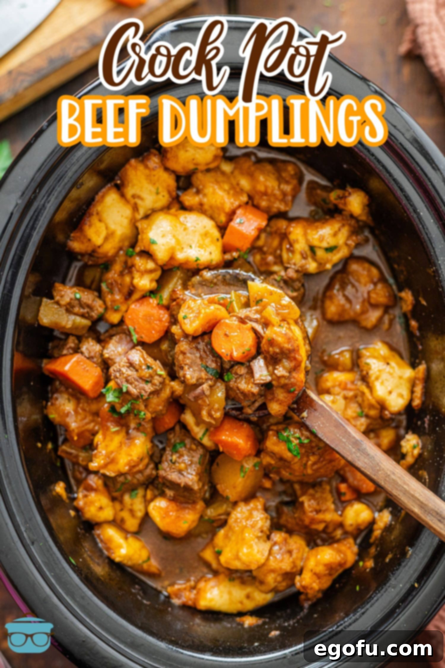 A wooden spoon scooping up delicious beef and dumplings from a Slow Cooker, highlighting the tender meat and fluffy biscuits.