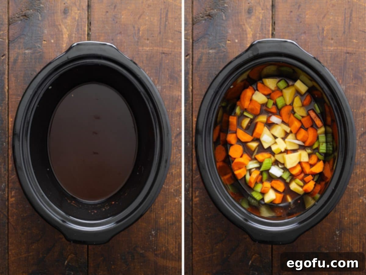 A slow cooker filled with beef broth, Worcestershire sauce, soy sauce, and a colorful array of fresh vegetables, ready for slow cooking.