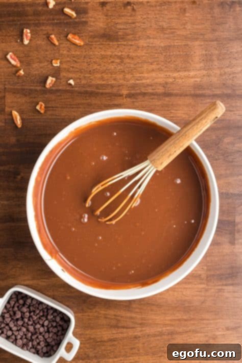 A bowl with sweetened condensed milk and fudge sauce mixed together.