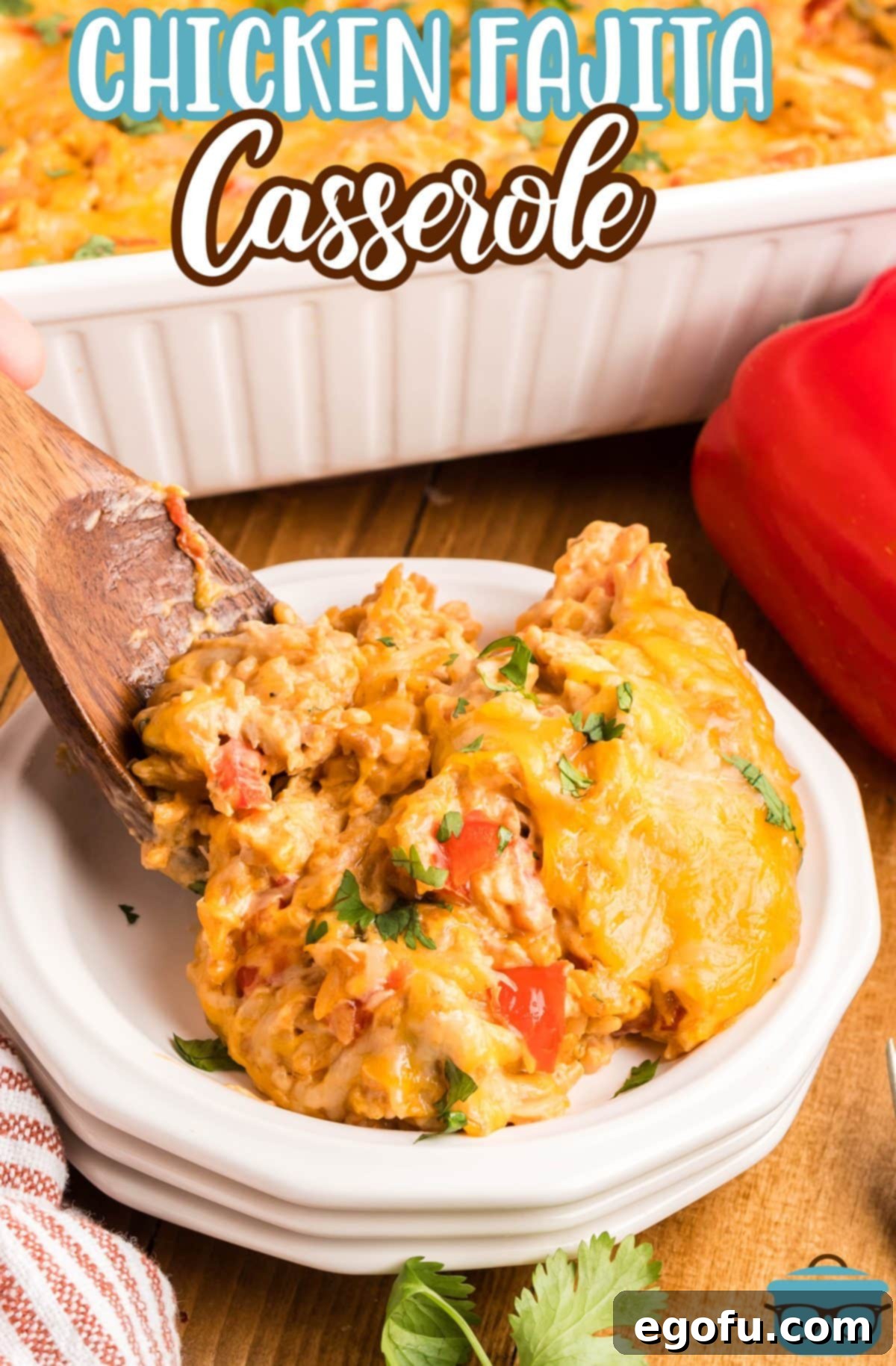 A wooden spoon setting a scoop of Chicken Fajita Casserole on a plate.