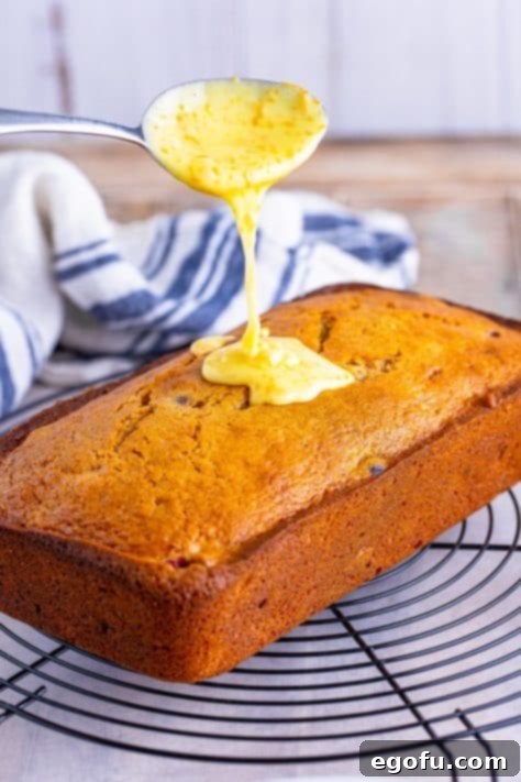 Starbucks Signature Cranberry Loaf 11 Orange icing being added to a loaf of bread.