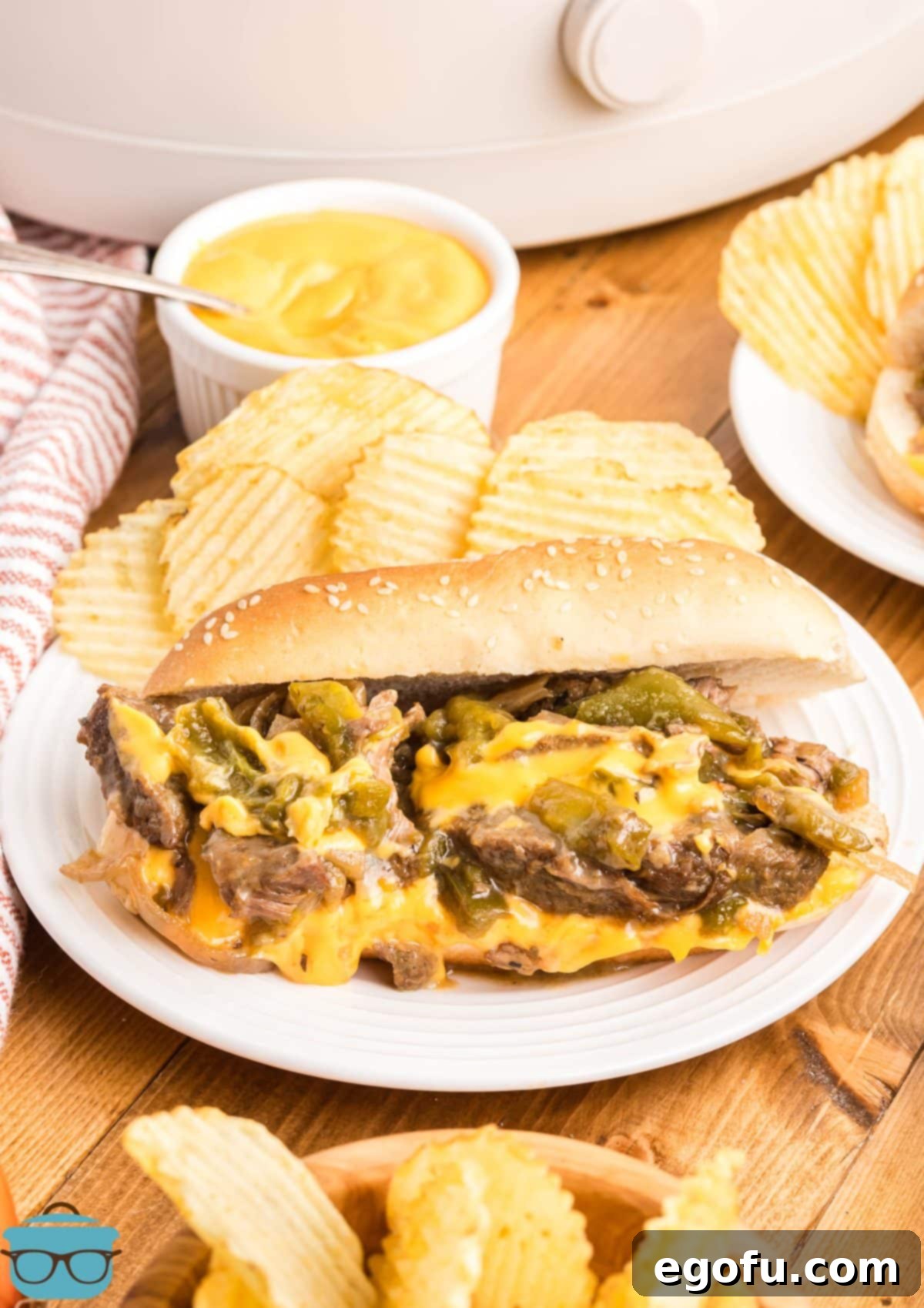 An open Philly Cheesesteak on a dinner plate.
