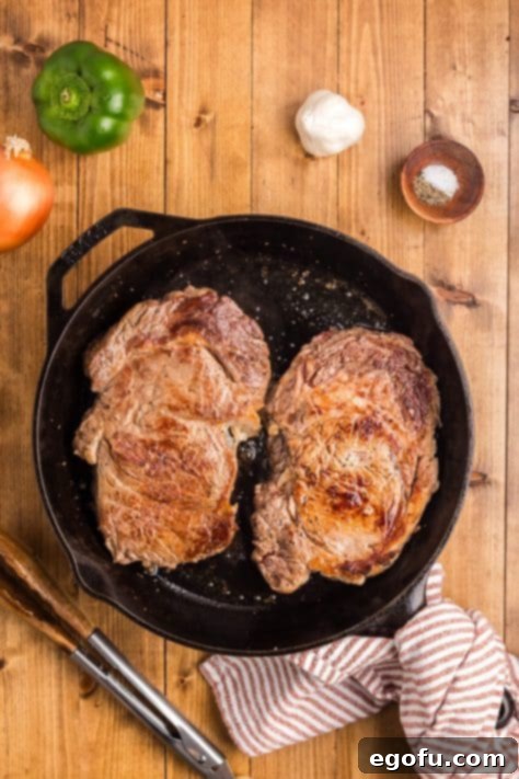 A skillet with browned steak.