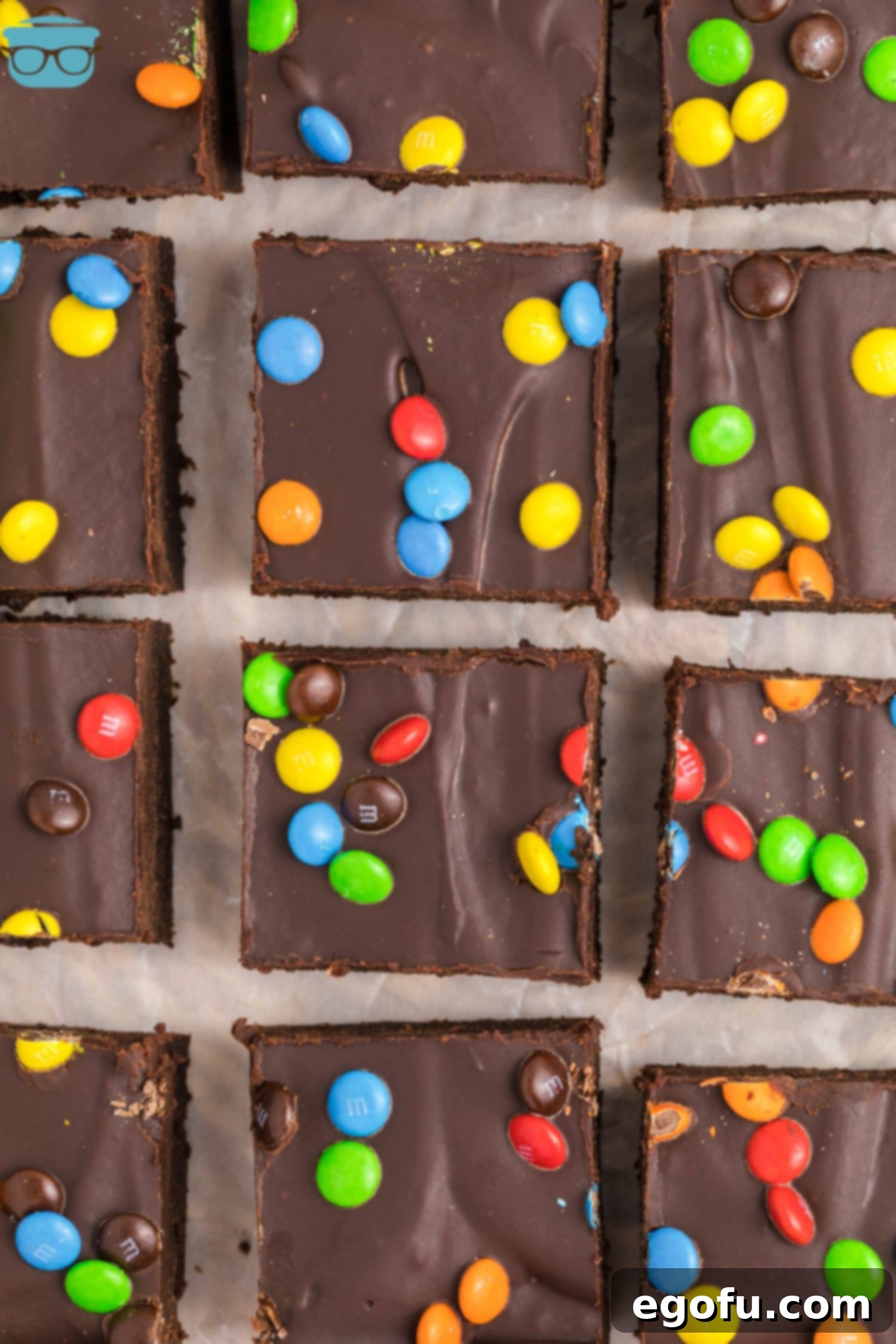 A few sliced Cosmic Brownies, showing their fudgy interior and colorful M&M topping.