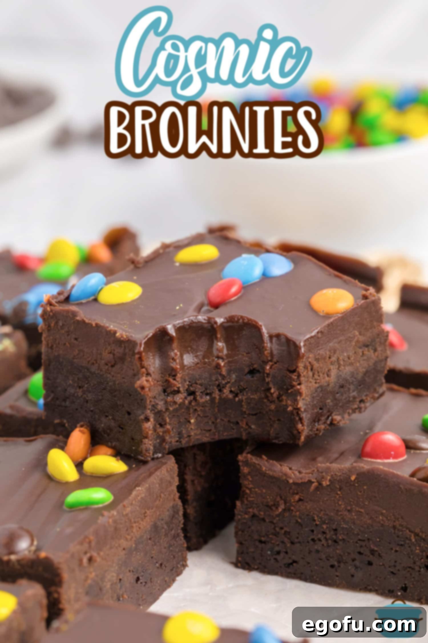 A batch of uncut Cosmic Brownies, with one piece missing, highlighting their irresistible appeal.