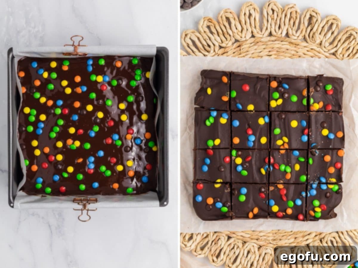 Chocolate frosting coated brownies with M&M pieces, ready for chilling and cutting.