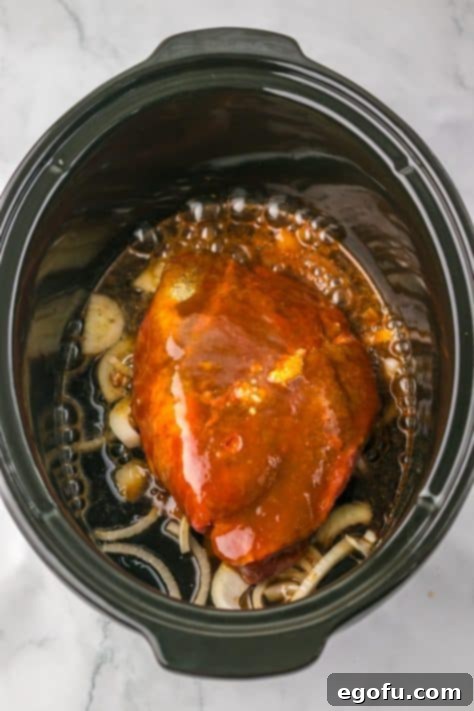 Tender Dr Pepper Slow Cooker Pulled Beef 10 Sauce covered roast in a slow cooker.